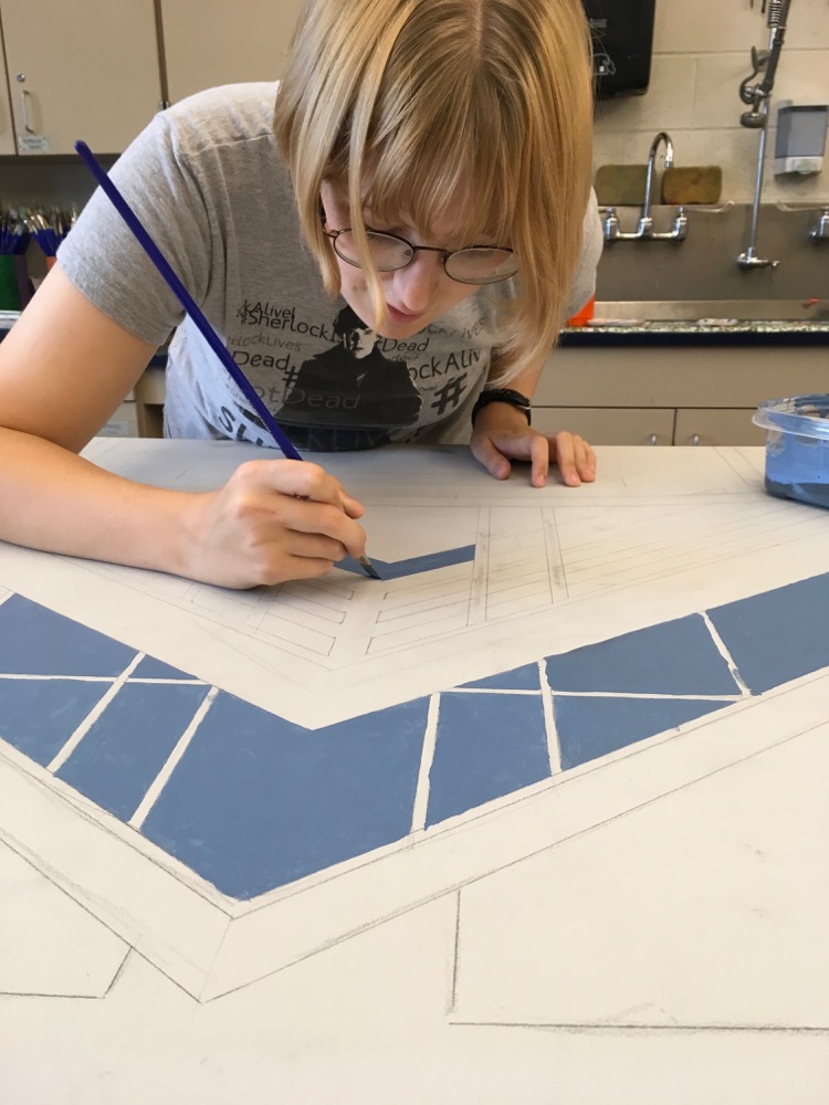 An MTHS Art Student applies paint to the MTSD Mural