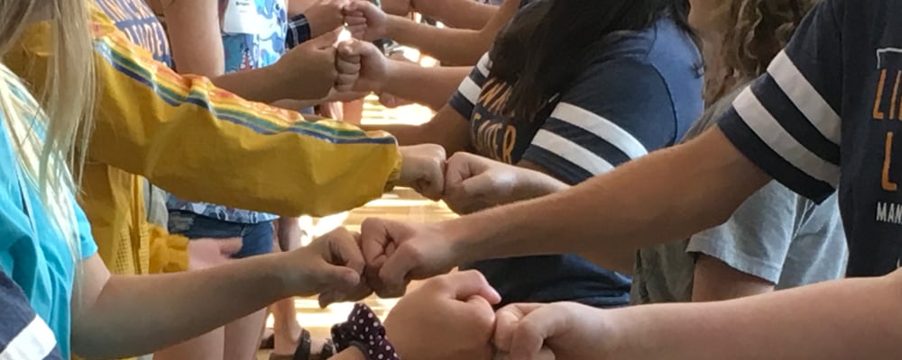 Students bumps fists in a line