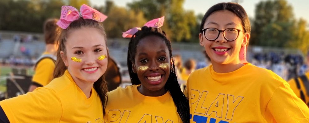 Three cheerleaders smile