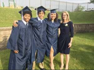 Photo of Superintendent Dr. Felty with three graduates