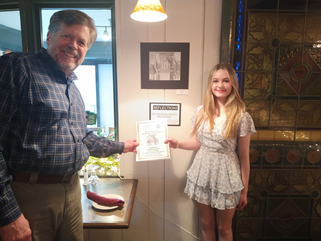high school student holding up her certificate with a gentleman to the left of her