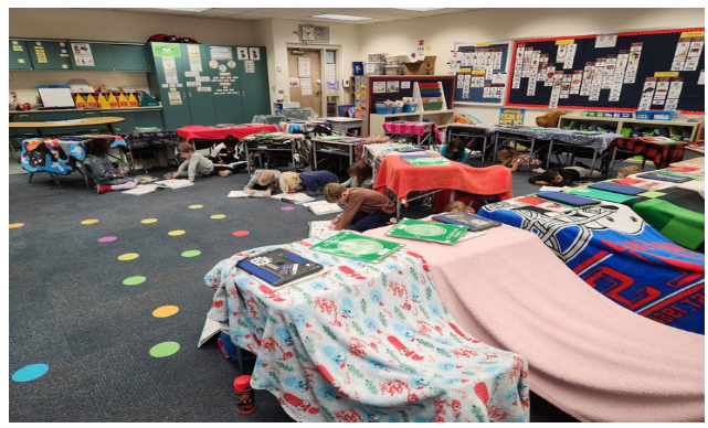 Students hiding under blankets to make forts out of the desks