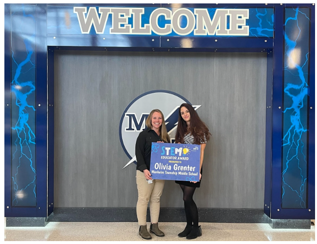 Olivia Grenter posing with a sign and a friend 